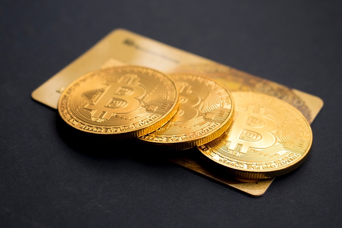 3 Bitcoin Münzen auf einer Kreditkarte